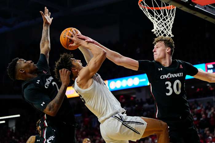 Cincinnati Bearcats forward Viktor Lakhin (30) blocks a shot by Xavier Musketeers guard Colby Jones (3) in the second half of the 90th Annual Crosstown Shootout NCAA basketball game between the Cincinnati Bearcats and the Xavier Musketeers at Fifth Third Arena in Cincinnati on Saturday, Dec. 10, 2022. The Musketeers held on down the stretch for a 80-77 win. Crosstown Shootout